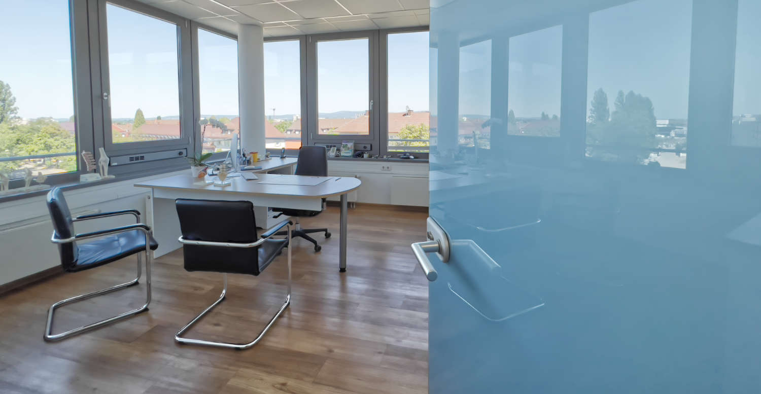 Bild zeigt in ein Arztzimmer mit großer Fensterfront